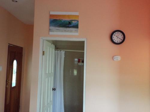 a clock on a wall next to a doorway with a door gmaxwell gmaxwell at LAKE VIEW CONDO in Belize City
