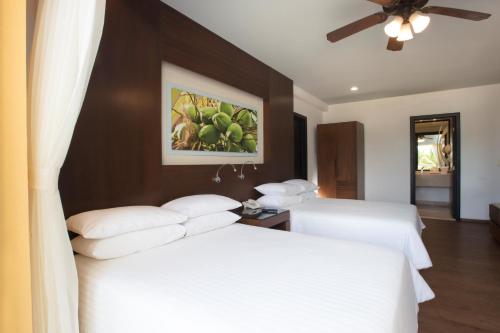 a hotel room with two beds and a ceiling fan at Krystal Grand Nuevo Vallarta in Nuevo Vallarta 