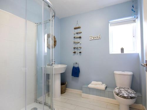 a bathroom with a shower and a toilet and a sink at Bwthyn y Mor in Porthmadog