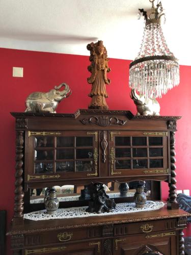 een grote houten kast in een kamer met een rode muur bij Villa Do Mar SW in Zambujeira do Mar