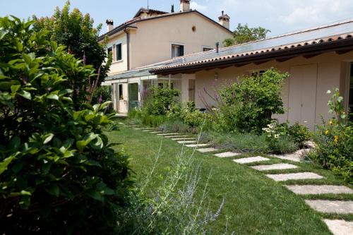 un jardín frente a una casa con césped en Boccadibacco, en San Pietro in Cariano
