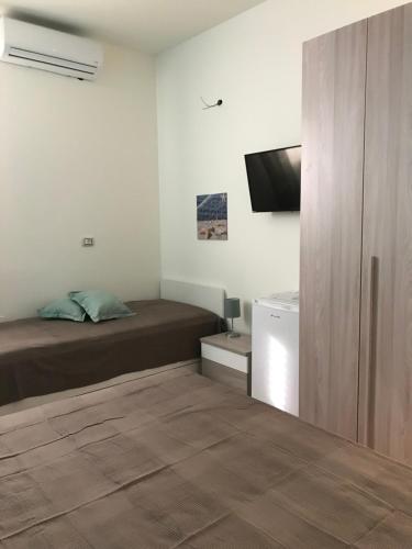 sypialnia z łóżkiem i telewizorem z płaskim ekranem w obiekcie B&B Stella del Mare w mieście Lampedusa