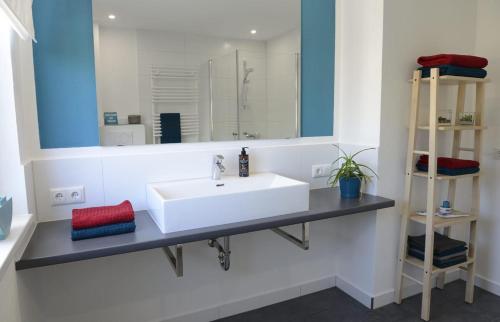 La salle de bains est pourvue d'un lavabo blanc et d'un miroir. dans l'établissement Deck 2 Laboe Ostsee, à Laboe