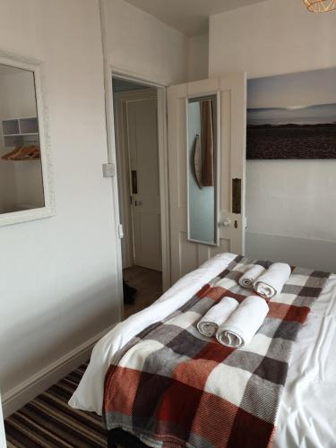 - une chambre avec un lit et des serviettes dans l'établissement The Studio Apartment, à Weymouth