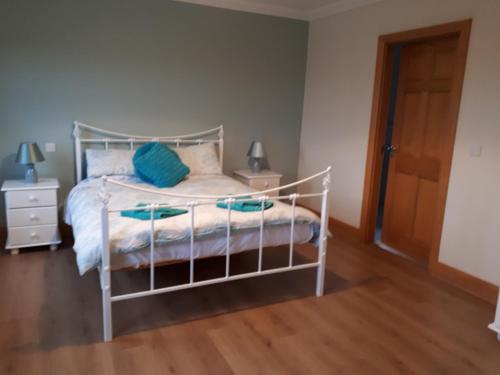 a bedroom with a white bed and a wooden floor at Country house in Galway