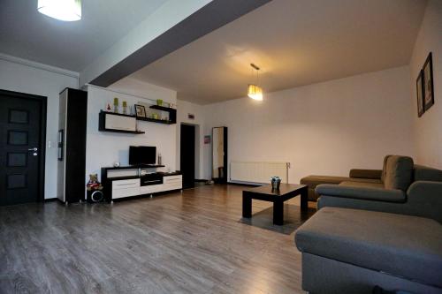 uma sala de estar com um sofá e uma televisão em Bloc Izvor em Piteşti