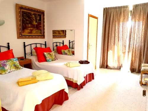 a bedroom with two beds with red and yellow pillows at El Artista in Villajoyosa