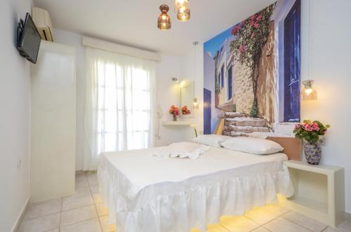 1 dormitorio con cama blanca y ventana en simos luxury apartments en Naxos