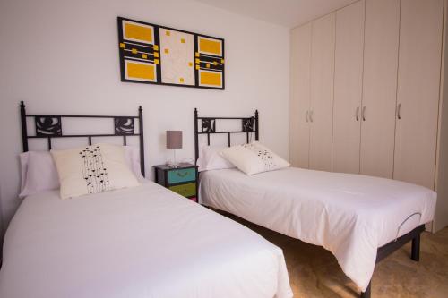 two beds sitting next to each other in a bedroom at Calle Lanzarote 29C in Playa del Ingles
