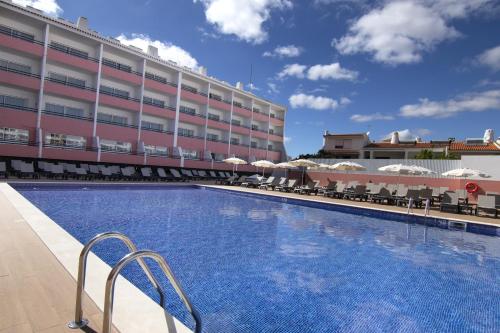 a large swimming pool in front of a building at Luna Hotel da Oura in Albufeira