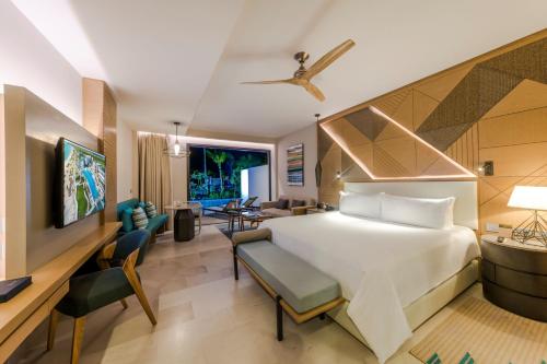 a bedroom with a bed and a living room at Haven Riviera Cancun - All Inclusive - Adults Only in Cancún