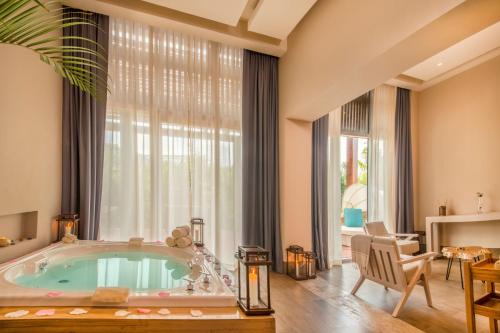 a bathroom with a jacuzzi tub in front of a window at Haven Riviera Cancun - All Inclusive - Adults Only in Cancún
