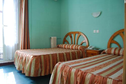 Säng eller sängar i ett rum på Hostal La Perla Asturiana