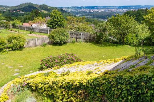 a garden with flowers and a fence in a field at Country House Zunko in Jelovec