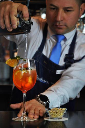 a man pouring a drink into a glass at Radisson Hotel Curico in Curicó
