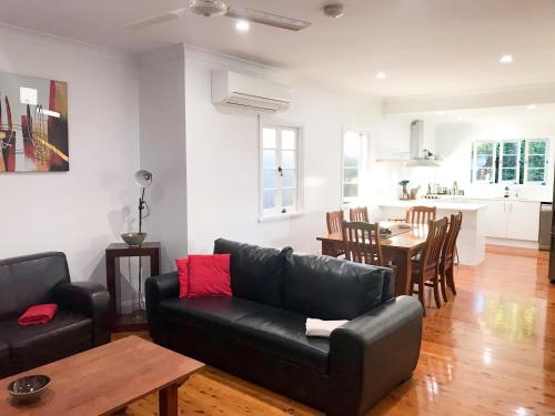 a living room with a black couch and a table at 4 bedroom house - Walk to Southbank in Brisbane