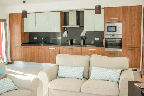 uma sala de estar com um sofá branco e uma cozinha em RestlessWave em Peniche