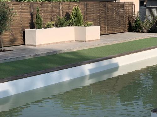 a pool of water in a garden with grass at Silver Lounge Siófok in Siófok