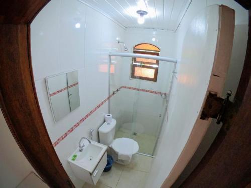 a small bathroom with a toilet and a sink at Alfa Mar Pousada in Abraão