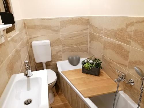 łazienka z toaletą, umywalką i wanną w obiekcie Apartment GNUBBEL am Wald w mieście Weißwasser
