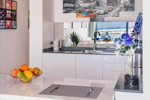 a kitchen with a bowl of fruit on a counter at Modern Frontline Puerto Banus Apartment M2 in Marbella