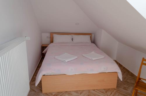 een kleine slaapkamer met een bed met twee handdoeken erop bij Mansarda mica cu baie proprie in Cluj-Napoca