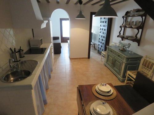 eine Küche mit einem Waschbecken und einem Tisch in einem Zimmer in der Unterkunft Villa Elisa Plaza Mayor in Chinchón