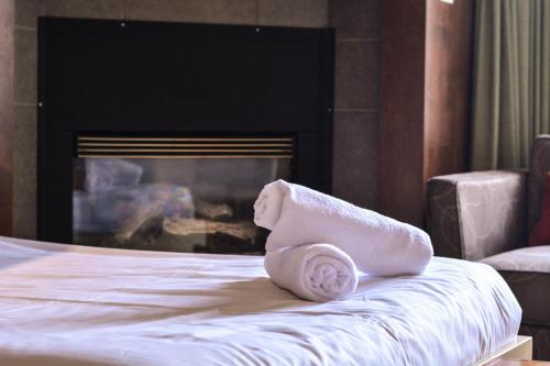 a towel sitting on top of a bed with a fireplace at Estrimont in Magog-Orford
