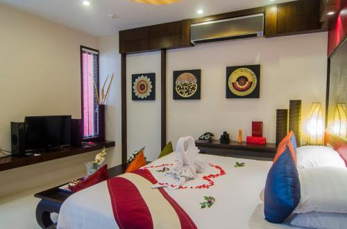 a bedroom with a bed and a tv in it at Kirikayan Boutique Resort - SHA Extra Plus in Chaweng
