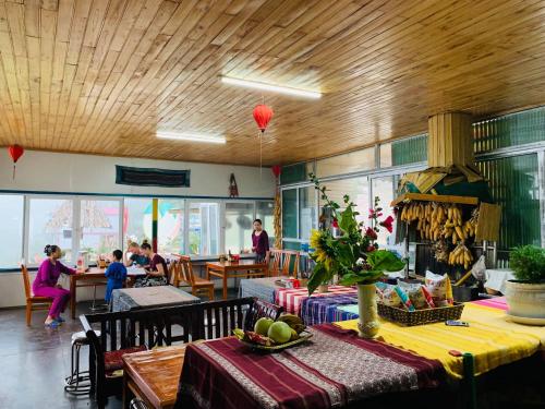 a restaurant with a table and people sitting at tables at Sapa Dao Homestay in Sa Pa