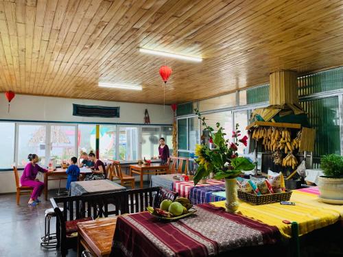 a restaurant with a table and people sitting at tables at Sapa Dao Homestay in Sapa