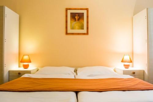 a bedroom with a large bed with two lamps at Villa A. Malka in Poděbrady