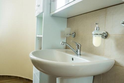 a white sink in a bathroom with a window at Villa A. Malka in Poděbrady