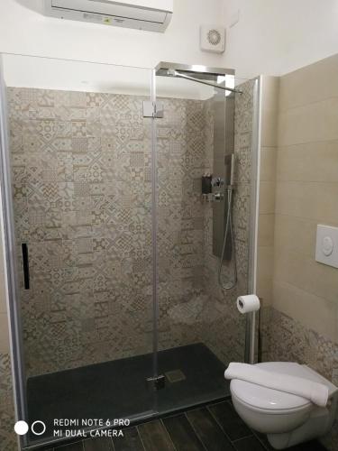 a bathroom with a glass shower with a toilet at Le Suite del Teatro cucinino privato in Taranto