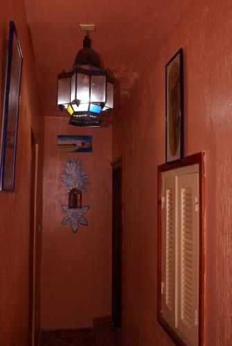 a hallway with a light on the wall and a lamp at Beach House in Asilah