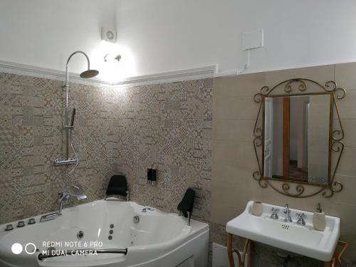 a bathroom with a tub and a sink and a mirror at Le Suite del Teatro cucinino privato in Taranto