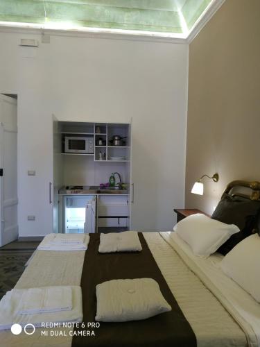 a bedroom with two beds and a kitchen in a room at Le Suite del Teatro cucinino privato in Taranto