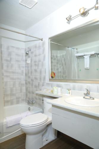 een witte badkamer met een toilet en een wastafel bij Fraser Inn in Prince George