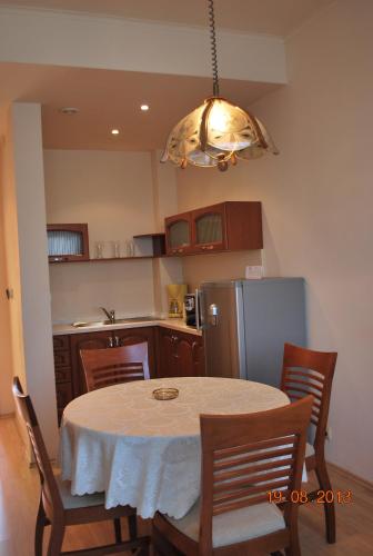 a kitchen with a table and a refrigerator at Apart Hotel Central Razgrad in Razgrad