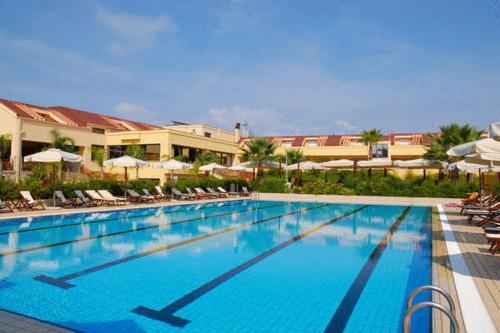 a large swimming pool with chairs and umbrellas at a hotel at Hotel La Principessa in Campora San Giovanni