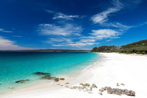 a beach with white sand and the blue water at Jervis Bay Motel in Huskisson