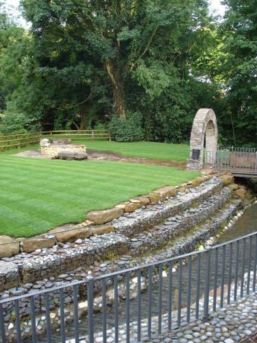 a garden with rocks and a fence and a park at The Jacobean Hotel in Coventry