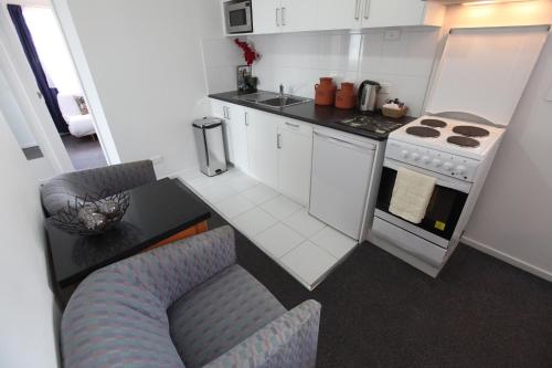 a kitchen with a stove, sink, and dishwasher at Mornington Motel in Mornington