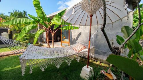 a hammock in the yard of a house at Coco Garden Pool Villas in Kubutambahan
