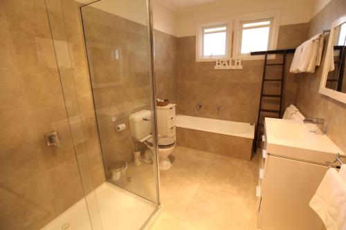 uma casa de banho com um chuveiro, um WC e um lavatório. em Mornington Motel em Mornington