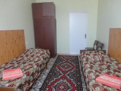 コムソモリスク・ナ・アムーレにあるGostinitsa Mayakのベッド2台とドアが備わる部屋