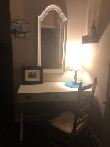 baño con tocador con lámpara y espejo en Little House on the Corner, en Livingston