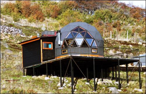 una casa con techo negro en una colina en Domo Carpe diem Patagonia en Coyhaique