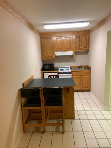 a kitchen with wooden cabinets and a black counter top at Executive Inn Yanceyville in Yanceyville