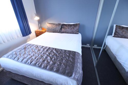 a bedroom with a large bed and a blue wall at Mornington Motel in Mornington